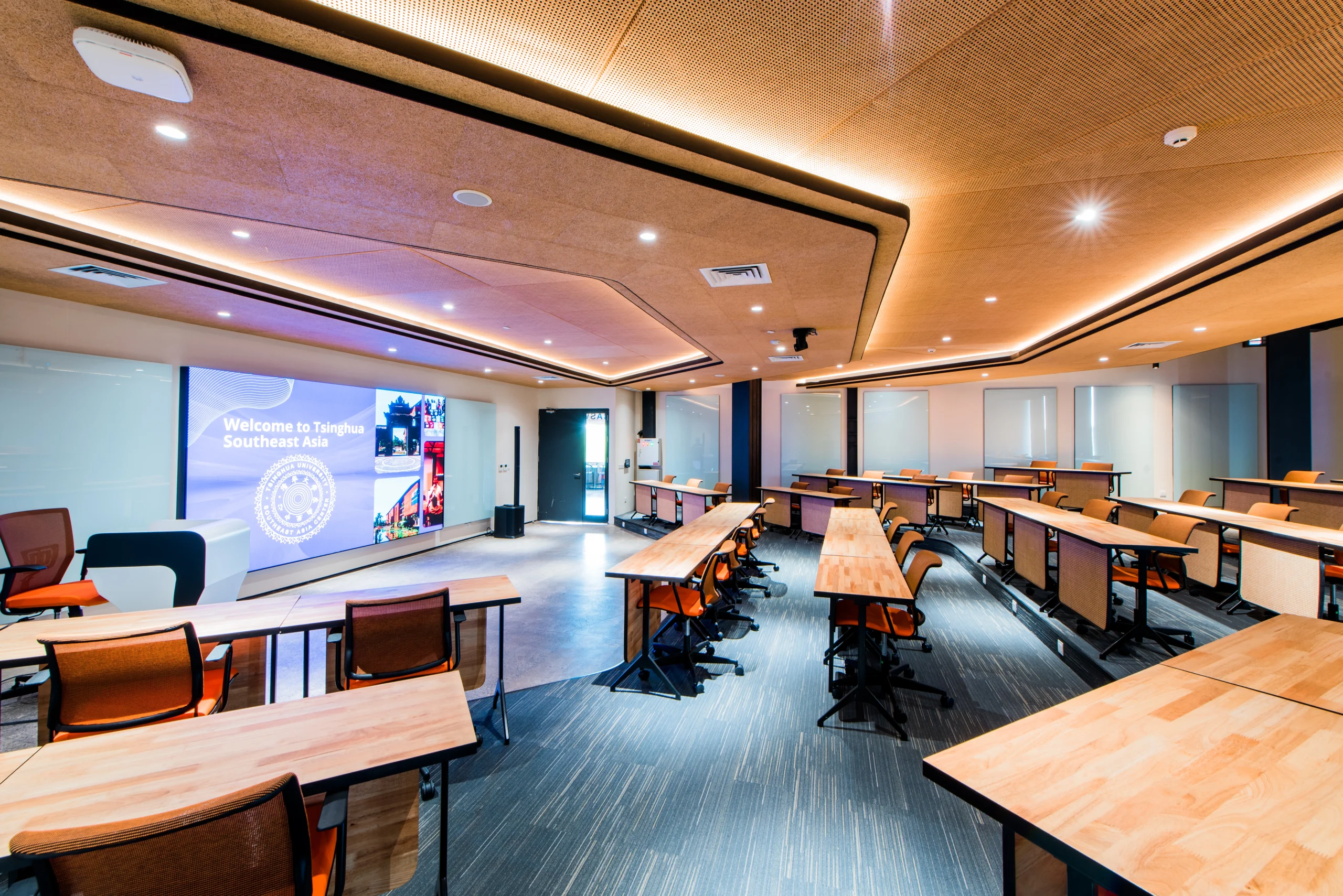 Saraswati  A tiered-floored classroom with 50 seats, perfect for lecture-style use, featuring students’ tables made from rubber wood and wood wool acoustic panels.